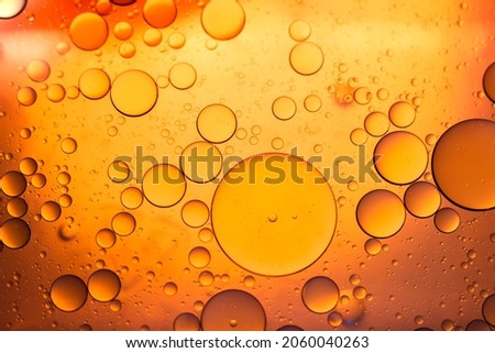 Water in oil in abstract style on yellow background. Orange liquid splash. Golden yellow bubble oil abstract background.