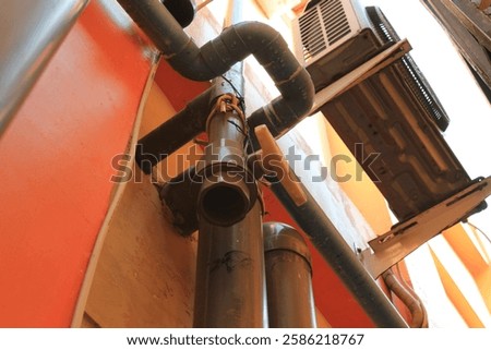 The water pipe system from the upper floor of a building. It looks like a sewage pipe.