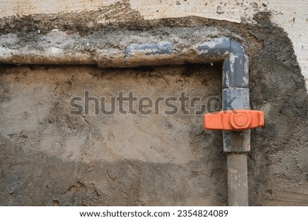 Water pipes with plastic valves on grungy walls