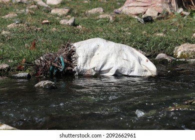 Water Pollution, Garbage And Trash, Discarded Plastic Polythene Debris Polluting A Waterway