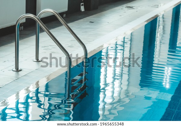 a water pool with blue transparent\
clear water, on which bright sunlight shines. Water lanes in the\
swimming pool. indoor sports field for\
swimming.