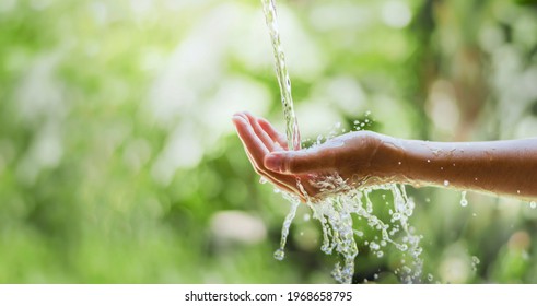 Water Pouring Flow On Woman Hand On Nature Background