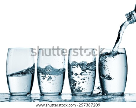 Water pouring into four glasses 