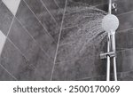 Water is pouring from the shower head into the shower room, close-up. Refreshing shower, cleanliness and hygiene