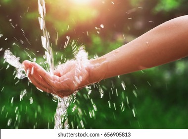 Water Pouring Splash In Hand And Nature Background With Sunshine