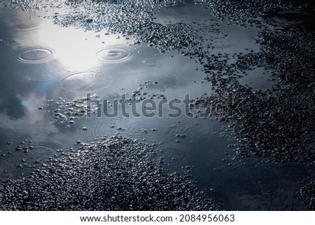 water puddles with water on cracked wet asphalt road after hard rain fall,rainy season background.