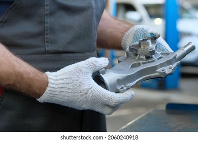 Water Pump For Car Engine. Close-up. An Auto Mechanic Inspects The Technical Condition Of The Spare Part Before Installation During Repair At A Service Station.