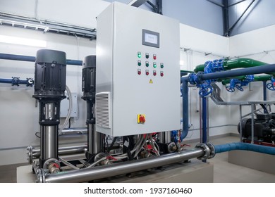 Water Pump Station And Pipeline With Tanks In An Industrial Room To Supply High Pressure Water For Firefight Tasks. Sprinkler Pipes And Control System To Provide Drink Water To People In Building