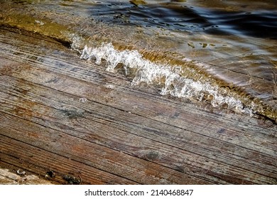 Water Pushes Onto The Old Wooden Boat Landing