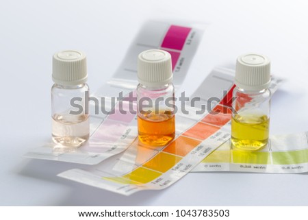 Water quality testing. Three vials with different colored liquids and color scales to determine water characteristics at home