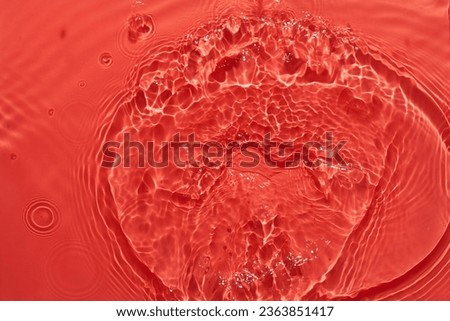 Water red surface abstract background. Waves and ripples texture of cosmetic aqua moisturizer with bubbles
