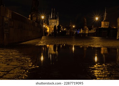 water reflections on charles bridge in Prague by night