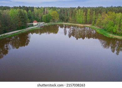 A Water Reservoir, A Lagoon Located In The Forest. The Shores Are Covered With Trees. A Small Hydroelectric Power Plant Is Visible. Photo From The Drone.