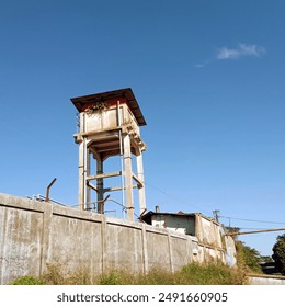 water reservoir tower in the factory with a bright blue sky as the background - Powered by Shutterstock