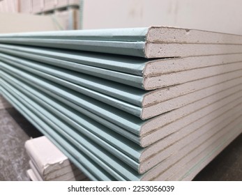 water resistant plasterboard sheets stacked in a hardware store. dry gypsum plaster. building material for the arrangement of cladding, partitions, ceilings in buildings.