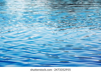 Water ripple texture background. Wavy water surface during sunset, golden light reflecting in the water. - Powered by Shutterstock