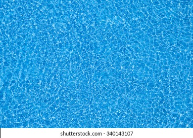 Water ripples on blue tiled swimming pool background. View from above. - Shutterstock ID 340143107