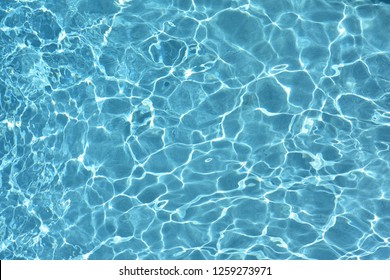 water ripples in pool during bright sunny day in blue pool