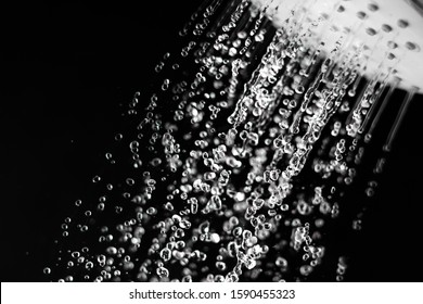 Water Running From A Shower Head On The Black Background. Water Saving Concept.