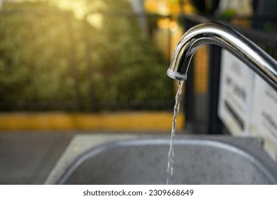 Water running from a tap. water drop dripping from the tap and water shortage. Global warming has caused drought. Climate change, global warming concept. Accidents and Disasters