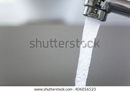 Water running from a tap into a kitchen sink