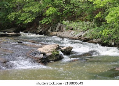 Water Running Through A Stream Over Rocks.