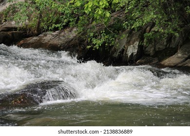 Water Running Through A Stream Over Rocks.