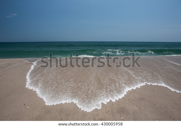 Water runs over a beautiful beach as the\
tide rises in Cape Cod, Massachusetts.\
