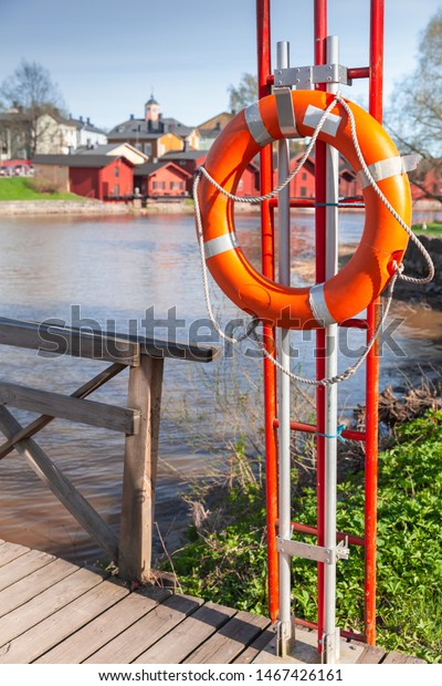 Water safety equipment. Red lifebuoy\
mounted on the bridge in Porvoo old town,\
Finland