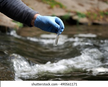 Water Sample. Gloved Hand Into The Water Collecting Tube. Analysis Of Water Purity, Environment, Ecology - Concept. Water Testing For Infections, Harmful Emissions