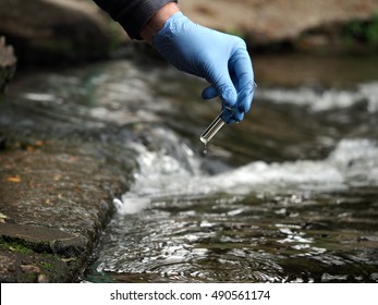 Water Sample. Gloved Hand Into The Water Collecting Tube. Analysis Of Water Purity, Environment, Ecology - Concept. Water Testing For Infections, Harmful Emissions