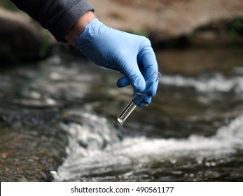 Water Sample. Gloved Hand Into The Water Collecting Tube. Analysis Of Water Purity, Environment, Ecology - Concept. Water Testing For Infections, Harmful Emissions