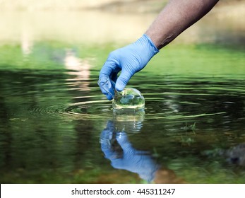 Water Sample. Hand In Glove Collects Water To Explore. Concept - Water Purity Analysis, Environment, Ecology. Water Testing For Infections, Permission To Swim