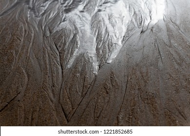 Water seeps away in the sand on beach. - Shutterstock ID 1221852685