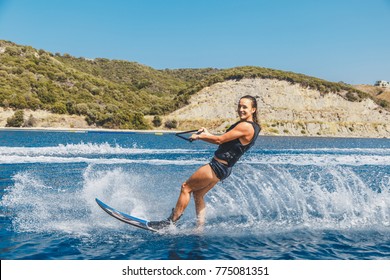 Water skis glides on the waves, female athlete on Aegean Sea, Greece