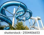 Water Slide, Amusement Park, Summer Fun - A blue water slide at an amusement park on a sunny summer day.