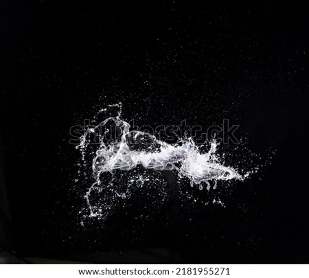 Water splash in air drop over black background, studio lighting high speed. water splashing throw in wind air and freeze stop with flash to see droplet texture for filter and layer