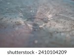 Water splash captured at 1 over 320th of a second, in the cold of winter on a partially rusted, steel drum lid.