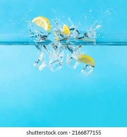 Water Splash With Fresh Lemon Fruit Slices And Ice Cubes. Minimal Summer Vacation Pool Or Beach Cocktail Drink Party Concept. Fun Bright Blue Background.