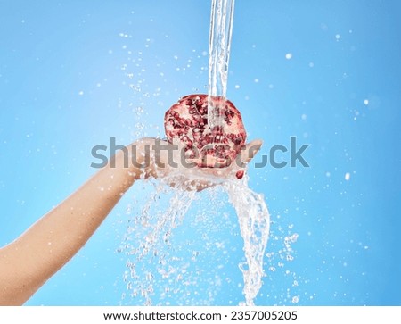 Water, splash and pomegranate with hands of woman for health, antioxidant and nutrition. Summer, organic and fruit with girl model for vitamin c for diet, food and clean detox in blue background
