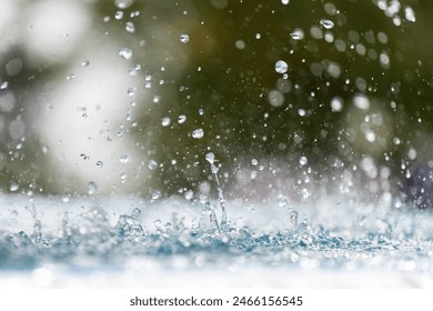 Water splashes from a fountain close-up. Falling drops of water against a green background. - Powered by Shutterstock