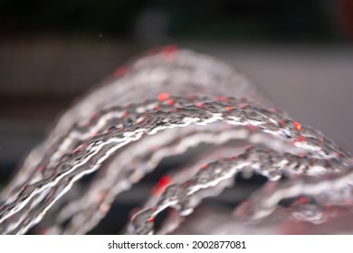 Water Splashes From Fountain On Dark Background. Natural Texture Of Only Water Of Fountain. High Waves Effect In Hot Summer With Copy Space. Water Sprays In Sunny Day Close-up.