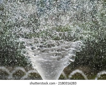 Water Splashes From Fountain On Dark Background. Natural Texture Of Only Water Of Fountain. High Waves Effect In Hot Summer With Copy Space. Water Sprays In Sunny Day Close-up.