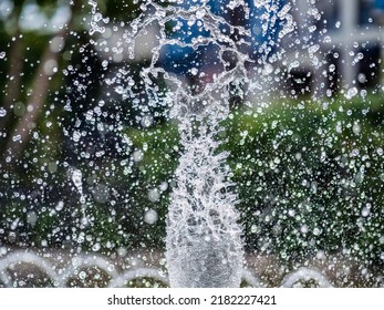 Water Splashes From Fountain On Dark Background. Natural Texture Of Only Water Of Fountain. High Waves Effect In Hot Summer With Copy Space. Water Sprays In Sunny Day Close-up.