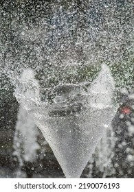 Water Splashes From Fountain On Dark Background. Natural Texture Of Only Water Of Fountain. High Waves Effect In Hot Summer With Copy Space. Water Sprays In Sunny Day Close-up.