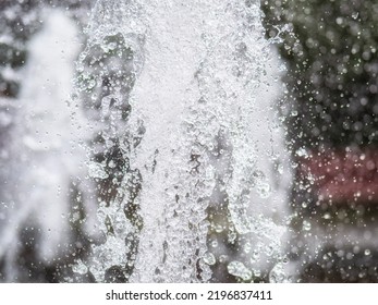 Water Splashes From Fountain On Dark Background. Natural Texture Of Only Water Of Fountain. High Waves Effect In Hot Summer With Copy Space. Water Sprays In Sunny Day Close-up.