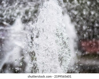 Water Splashes From Fountain On Dark Background. Natural Texture Of Only Water Of Fountain. High Waves Effect In Hot Summer With Copy Space. Water Sprays In Sunny Day Close-up.