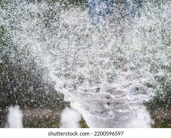 Water Splashes From Fountain On Dark Background. Natural Texture Of Only Water Of Fountain. High Waves Effect In Hot Summer With Copy Space. Water Sprays In Sunny Day Close-up.