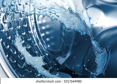 Water splashes in washing machine drum, closeup