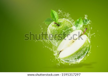 Water splashing on Fresh green apple on Green background.